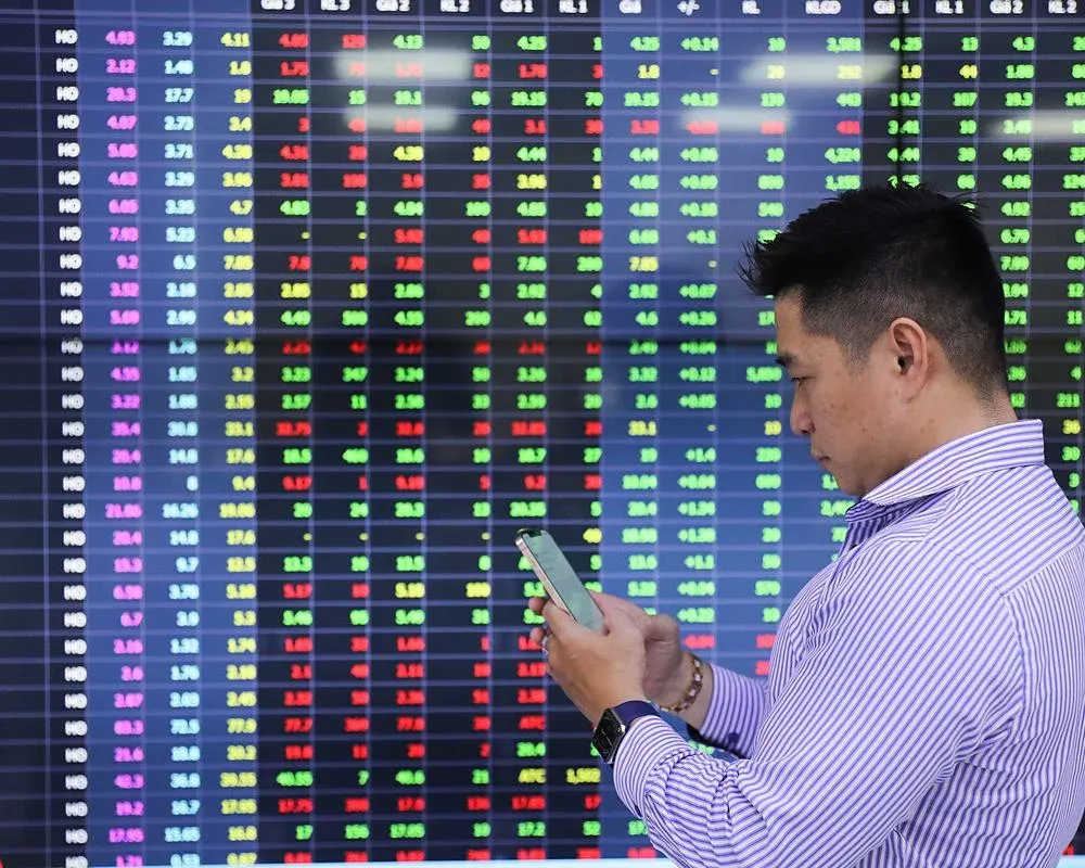 Nhà đầu tư cá nhân theo dõi bảng điện tử chứng khoán