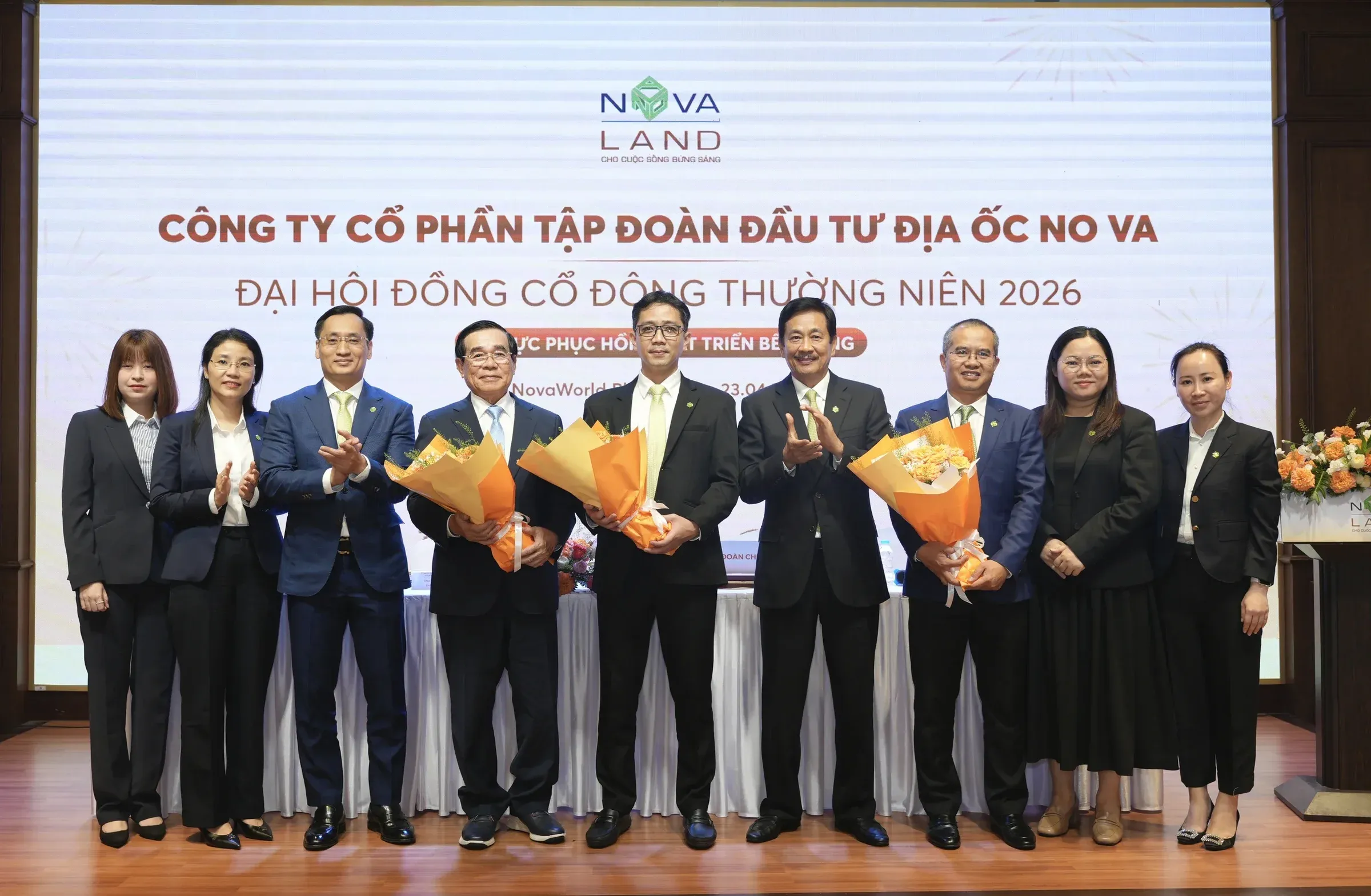 Lãnh đạo Novaland tại ĐHĐCĐ thường niên 2026, ông Bùi Cao Nhật Quân (áo xanh, giữa) nhận hoa sau khi được bầu làm Chủ tịch HĐQT