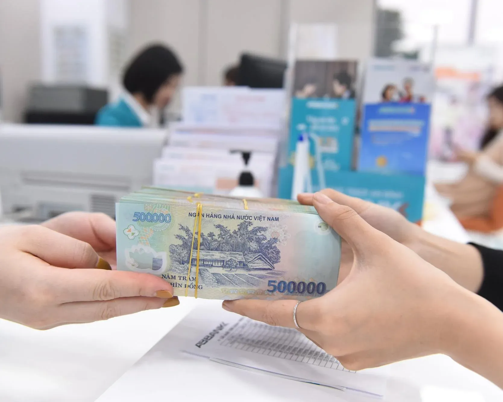Customer depositing cash at a Vietnamese bank counter